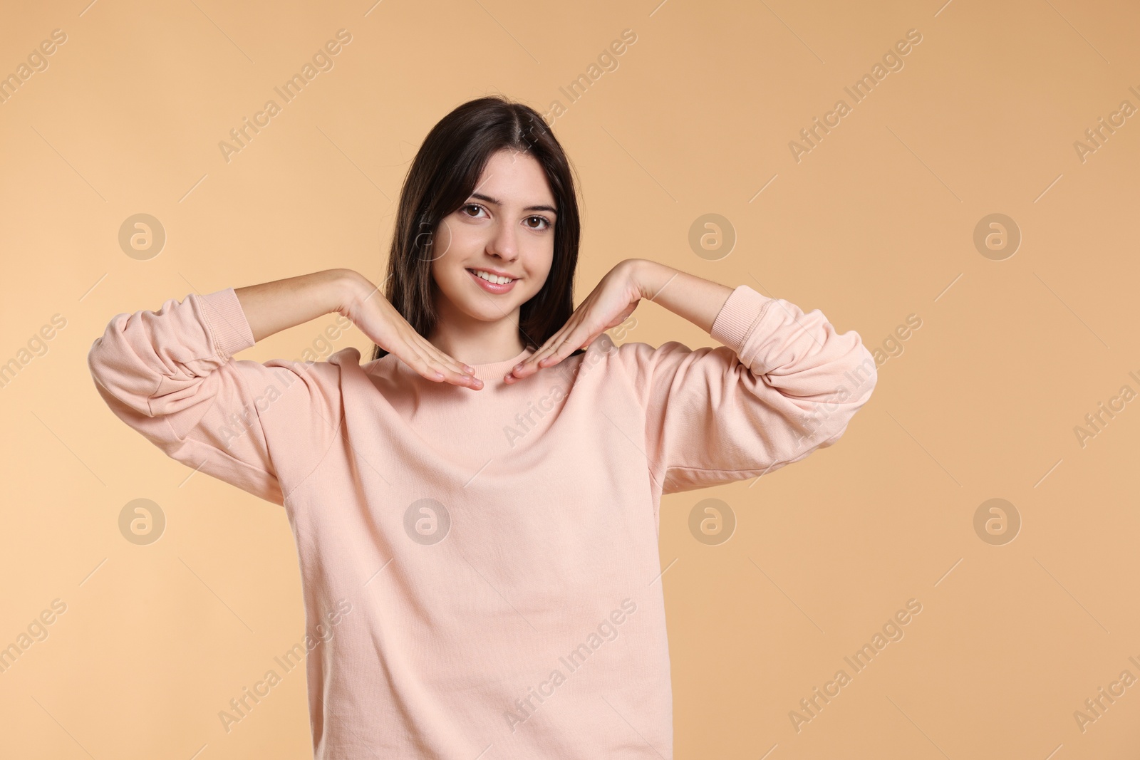 Photo of Portrait of cute teenage girl on beige background