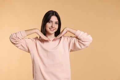 Portrait of cute teenage girl on beige background