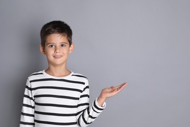 Photo of Portrait of cute little boy on grey background, space for text