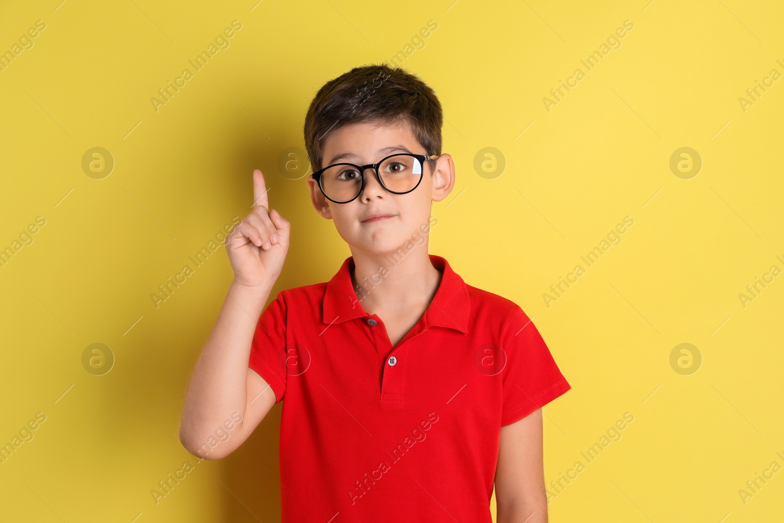 Photo of Portrait of cute little boy on yellow background