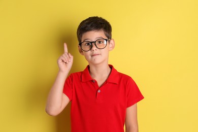 Photo of Portrait of cute little boy on yellow background