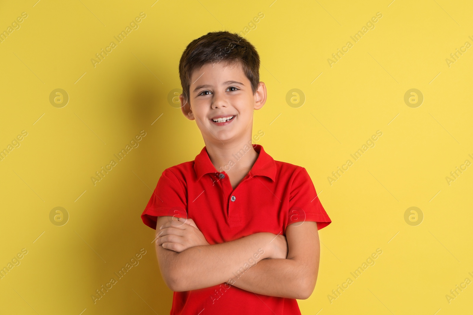 Photo of Portrait of cute little boy on yellow background