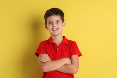 Photo of Portrait of cute little boy on yellow background