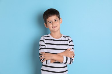 Photo of Portrait of cute little boy on light blue background