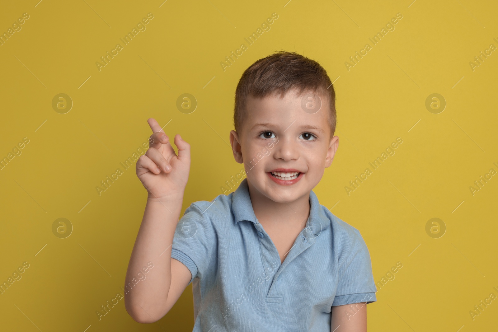 Photo of Portrait of cute little boy on yellow background