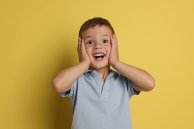 Photo of Portrait of cute little boy on yellow background