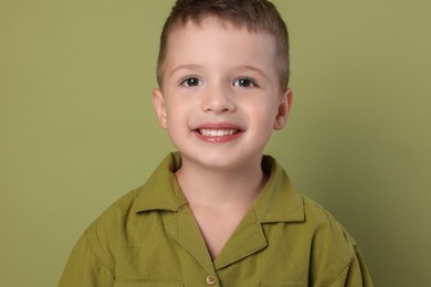 Photo of Portrait of cute little boy on green background