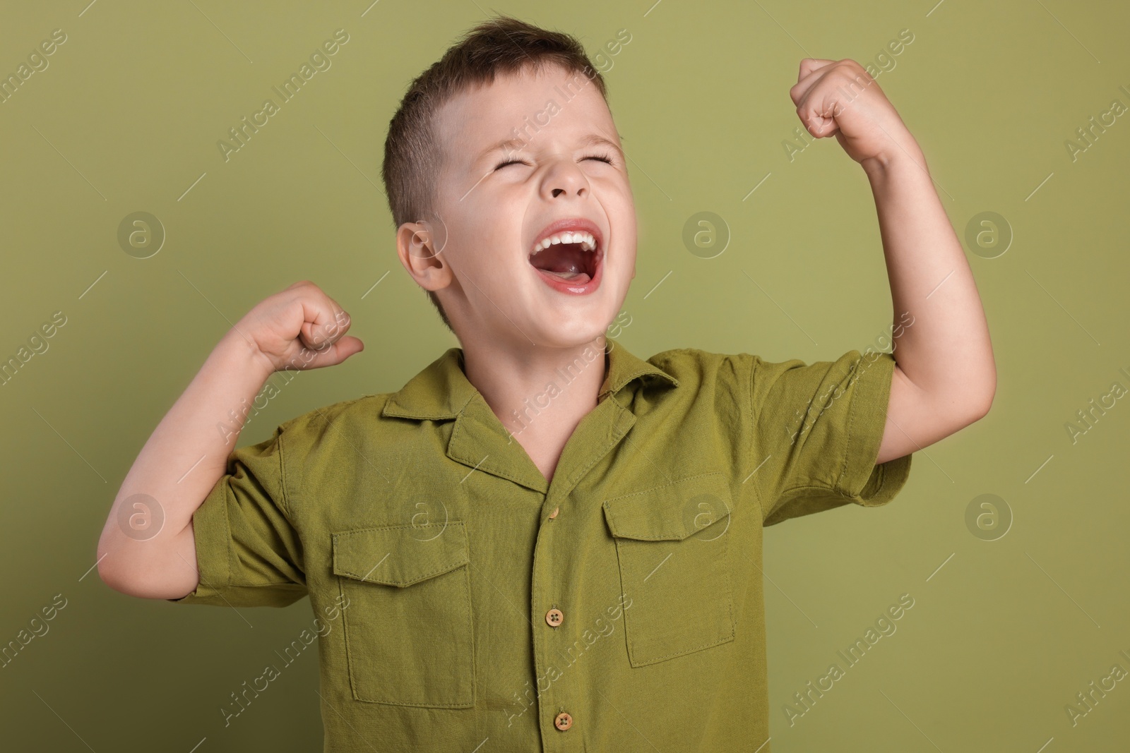 Photo of Portrait of cute little boy on green background