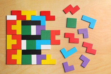 Colorful puzzle pieces on wooden table, flat lay