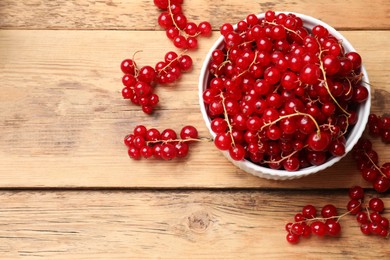 Photo of Fresh red currants in bowl on wooden table, top view. Space for text