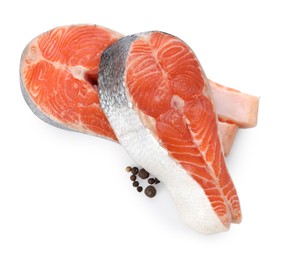 Photo of Two fresh salmon steaks and peppercorns isolated on white, top view