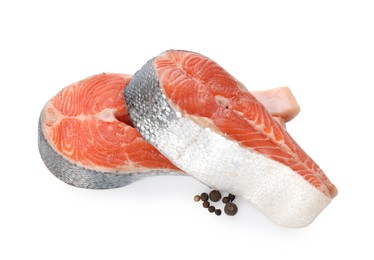 Photo of Two fresh salmon steaks and peppercorns isolated on white, above view