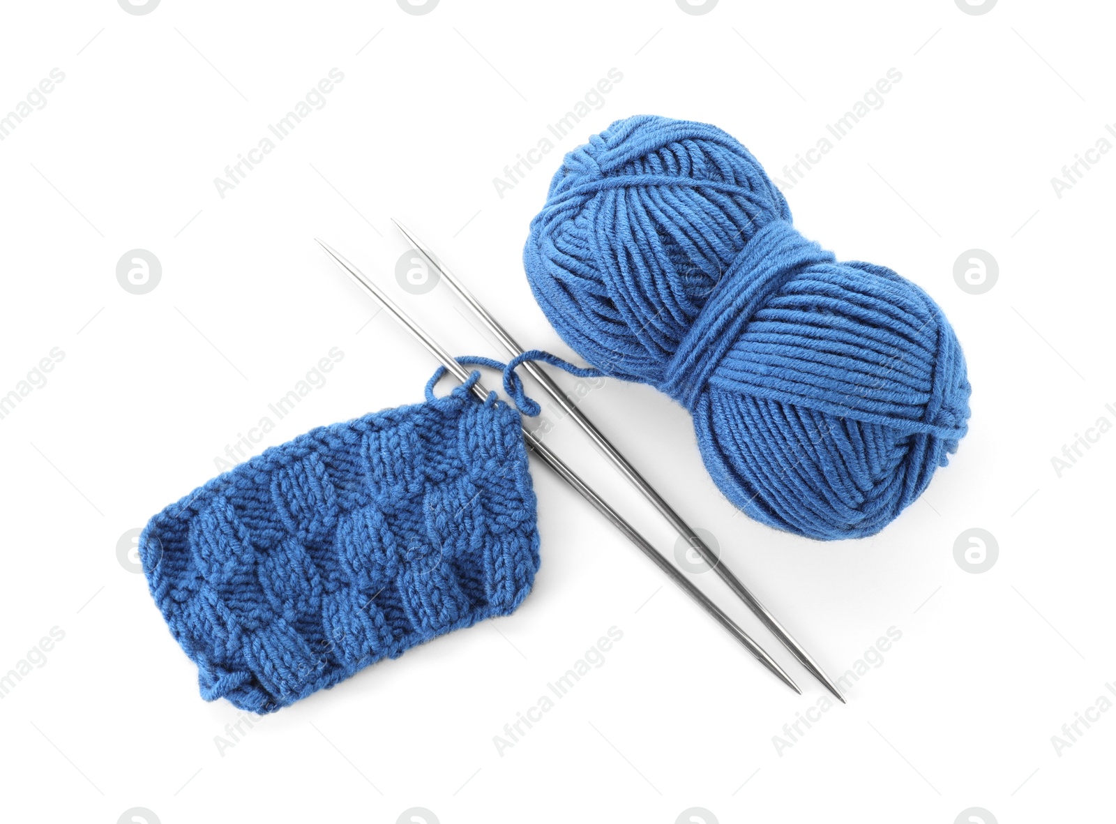 Photo of Skein of blue yarn, knitted fabric and needles isolated on white, top view