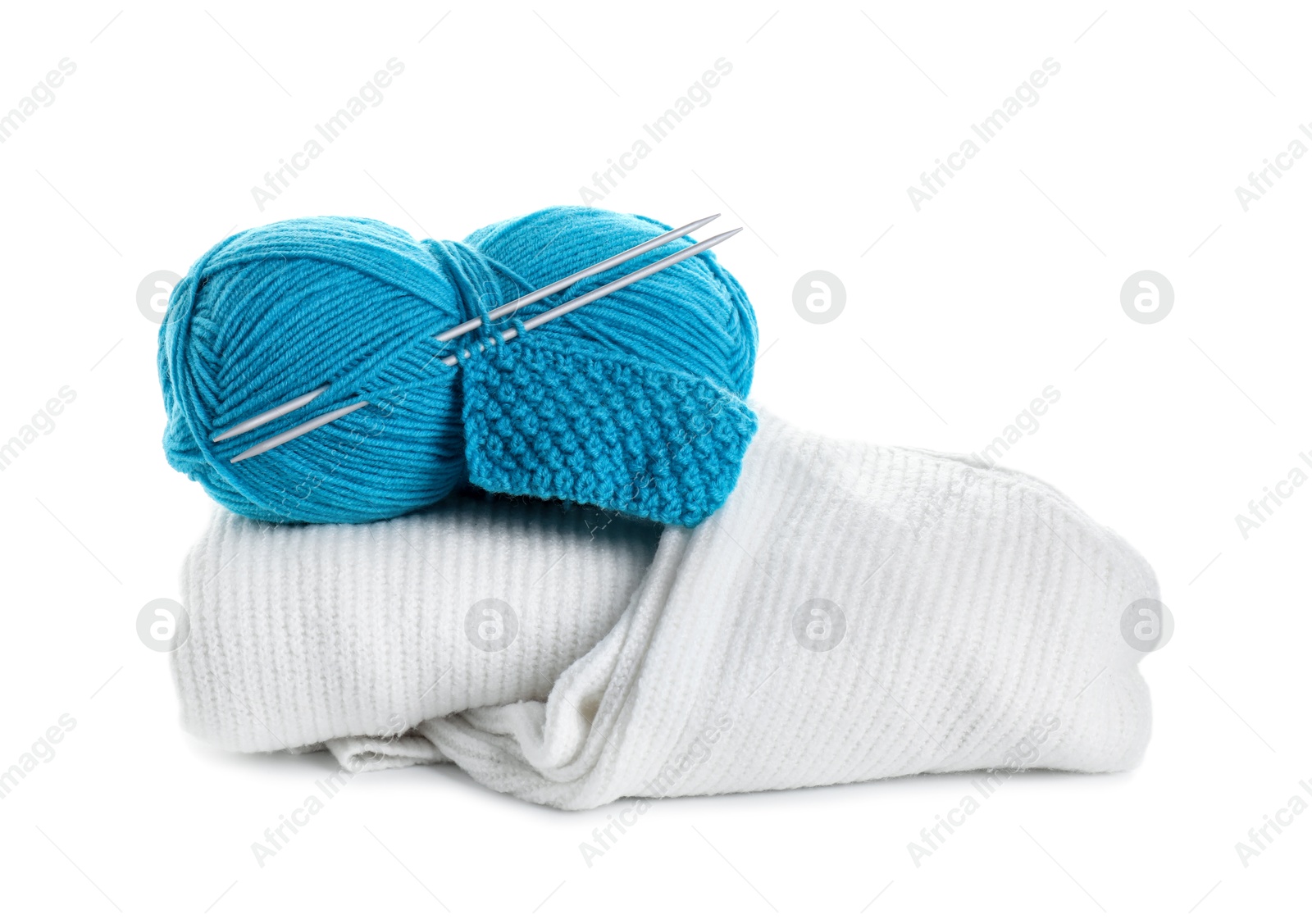 Photo of Skein of yarn, knitting needles, pattern sample and sweaters isolated on white