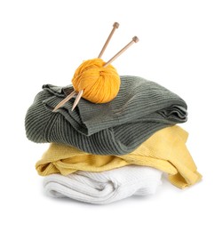 Photo of Ball of yarn with knitting needles and sweaters isolated on white