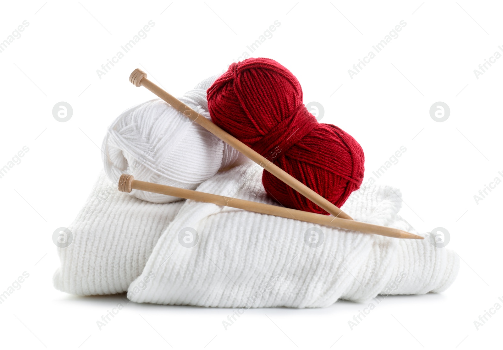 Photo of Different yarns, knitting needles and sweater isolated on white