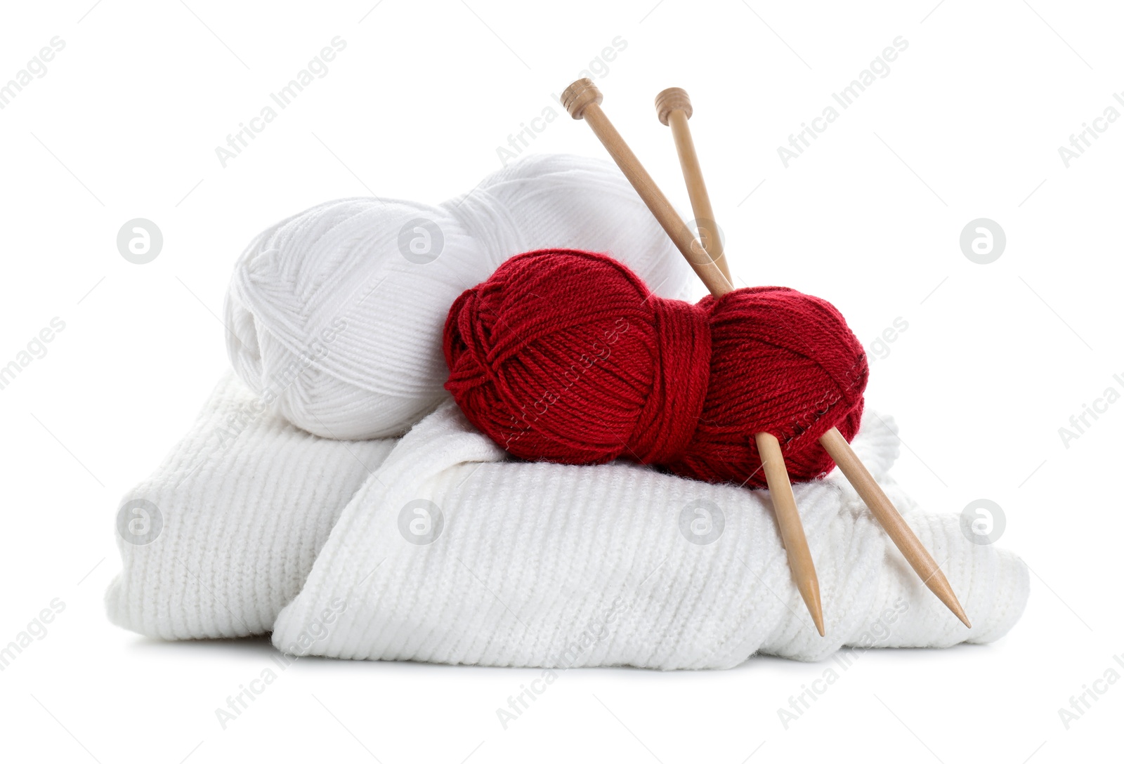 Photo of Different yarns, knitting needles and sweater isolated on white