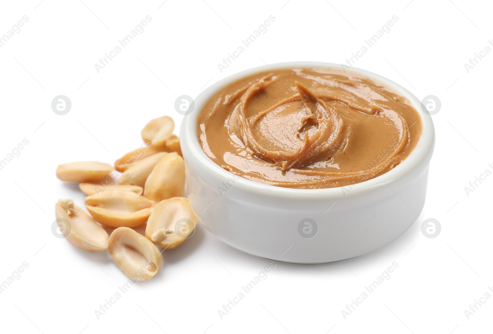 Photo of Tasty peanut butter in bowl and groundnuts isolated on white