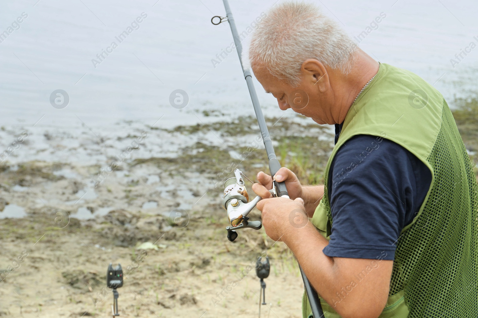 Photo of Fisherman with rod fishing near lake at summer