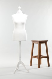 One female mannequin and stool on light background