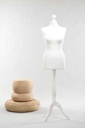 Photo of One female mannequin and poufs on light background