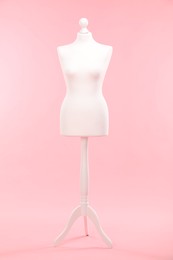 One female mannequin on stand against pink background