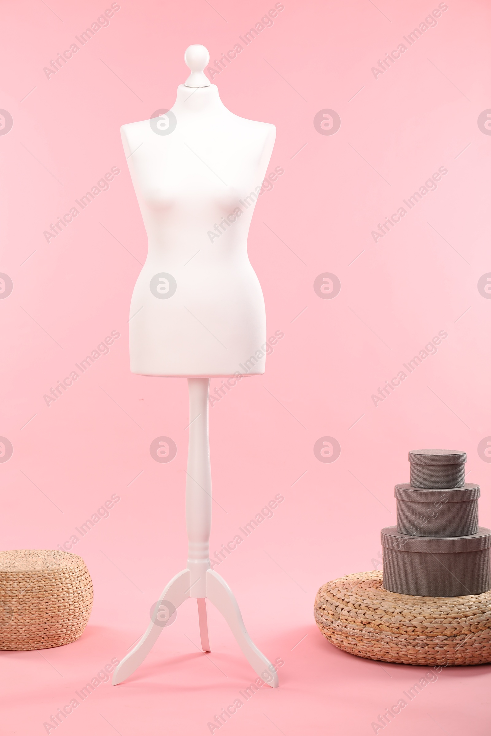 Photo of Female mannequin, poufs and boxes on pink background