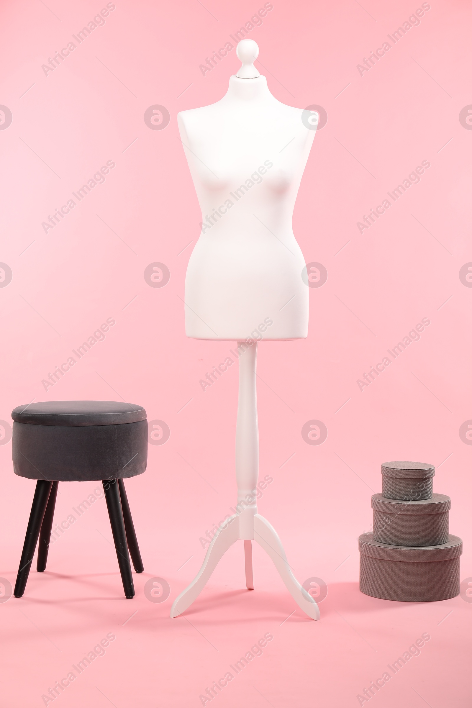 Photo of Female mannequin, ottoman and boxes on pink background