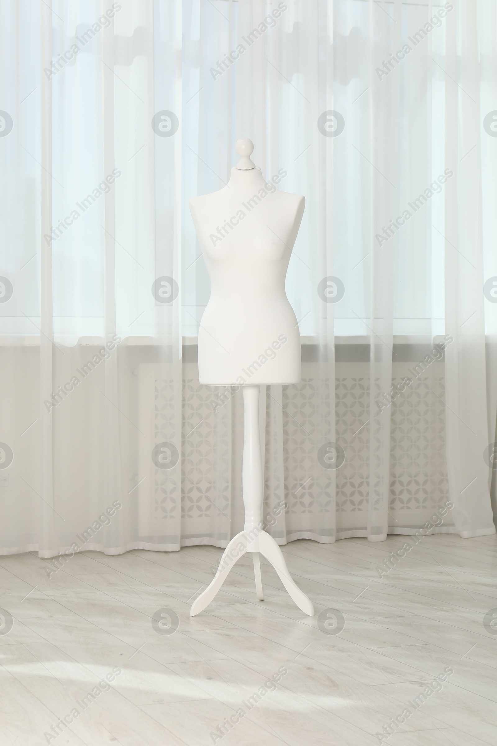 Photo of One female mannequin on stand near window indoors