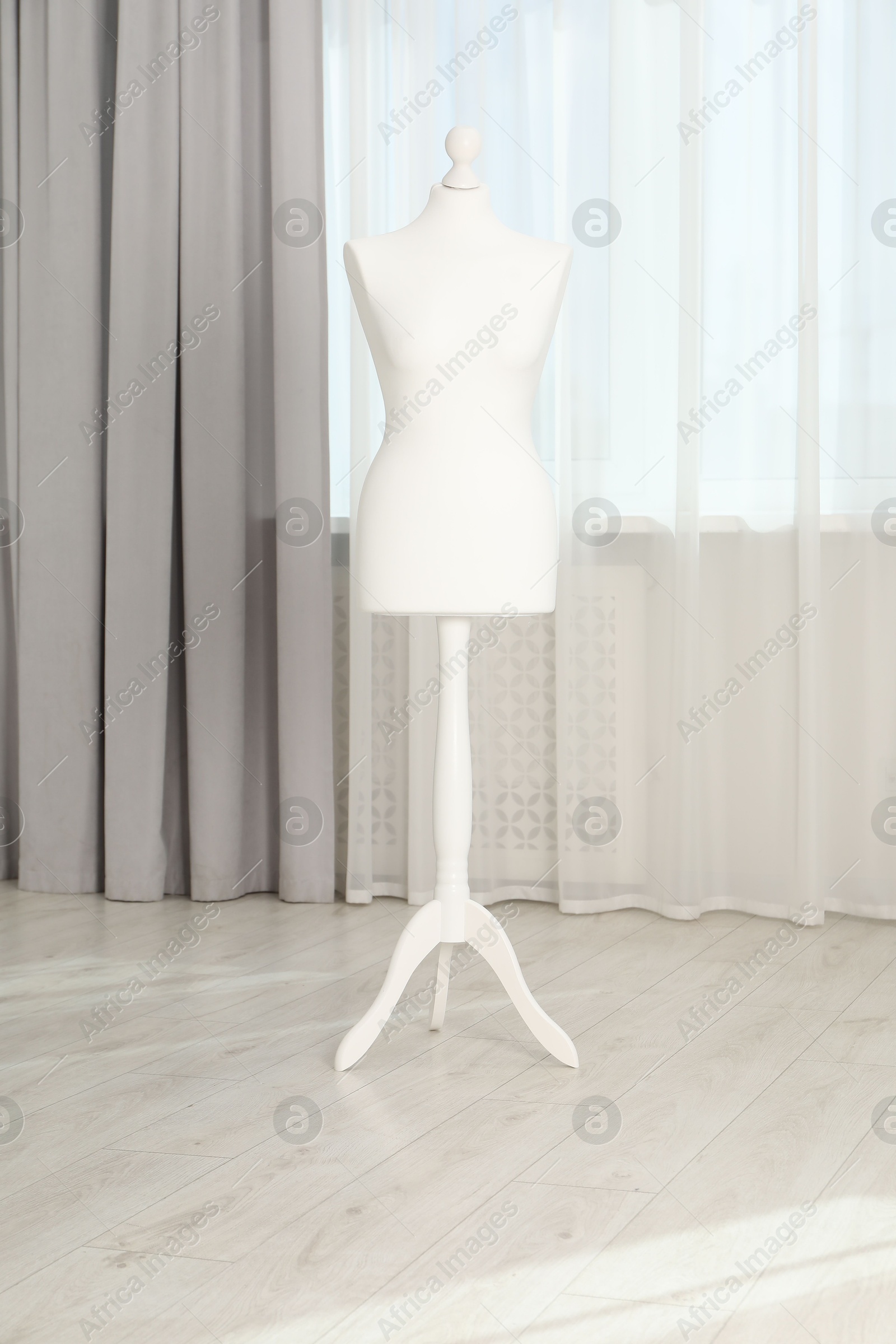 Photo of One female mannequin on stand near window indoors