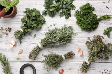 Photo of Different aromatic herbs on white wooden table, flat lay