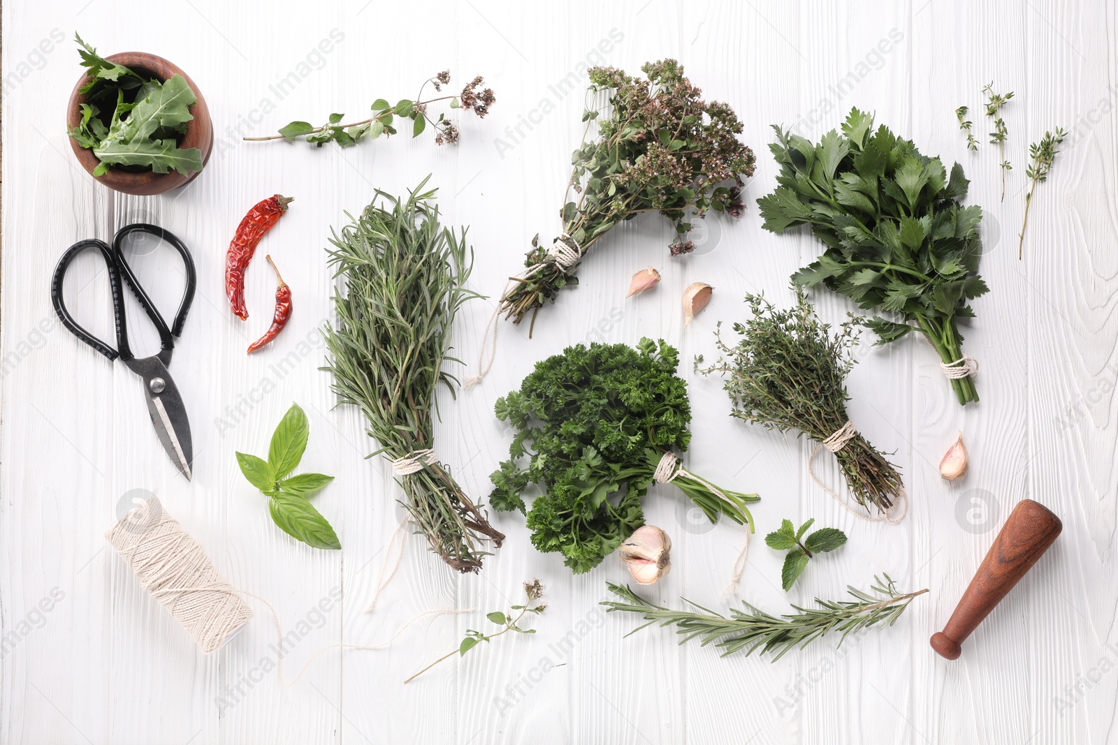 Photo of Different aromatic herbs, spool of thread and scissors on white wooden table, flat lay