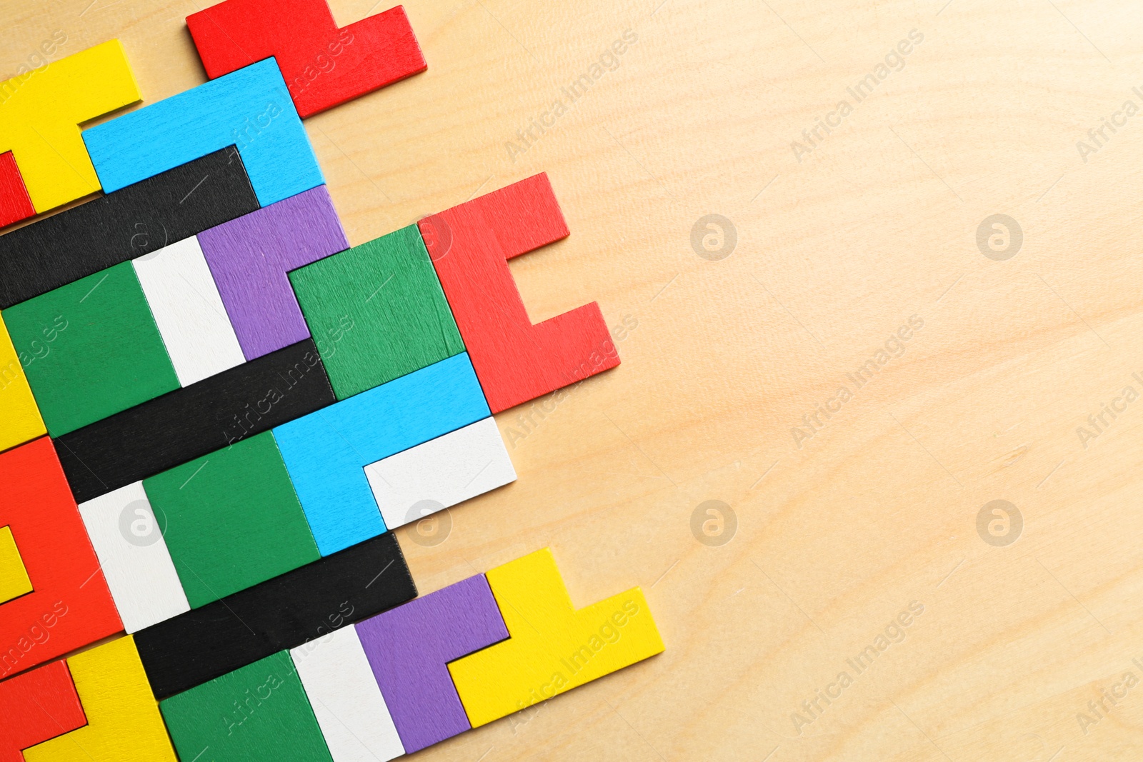 Photo of Colorful puzzle pieces on wooden table, top view. Space for text