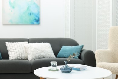 Photo of Coffee table with books and decor near sofa in living room, selective focus