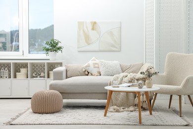 Photo of Comfortable sofa, armchair, coffee table and folding screen in living room