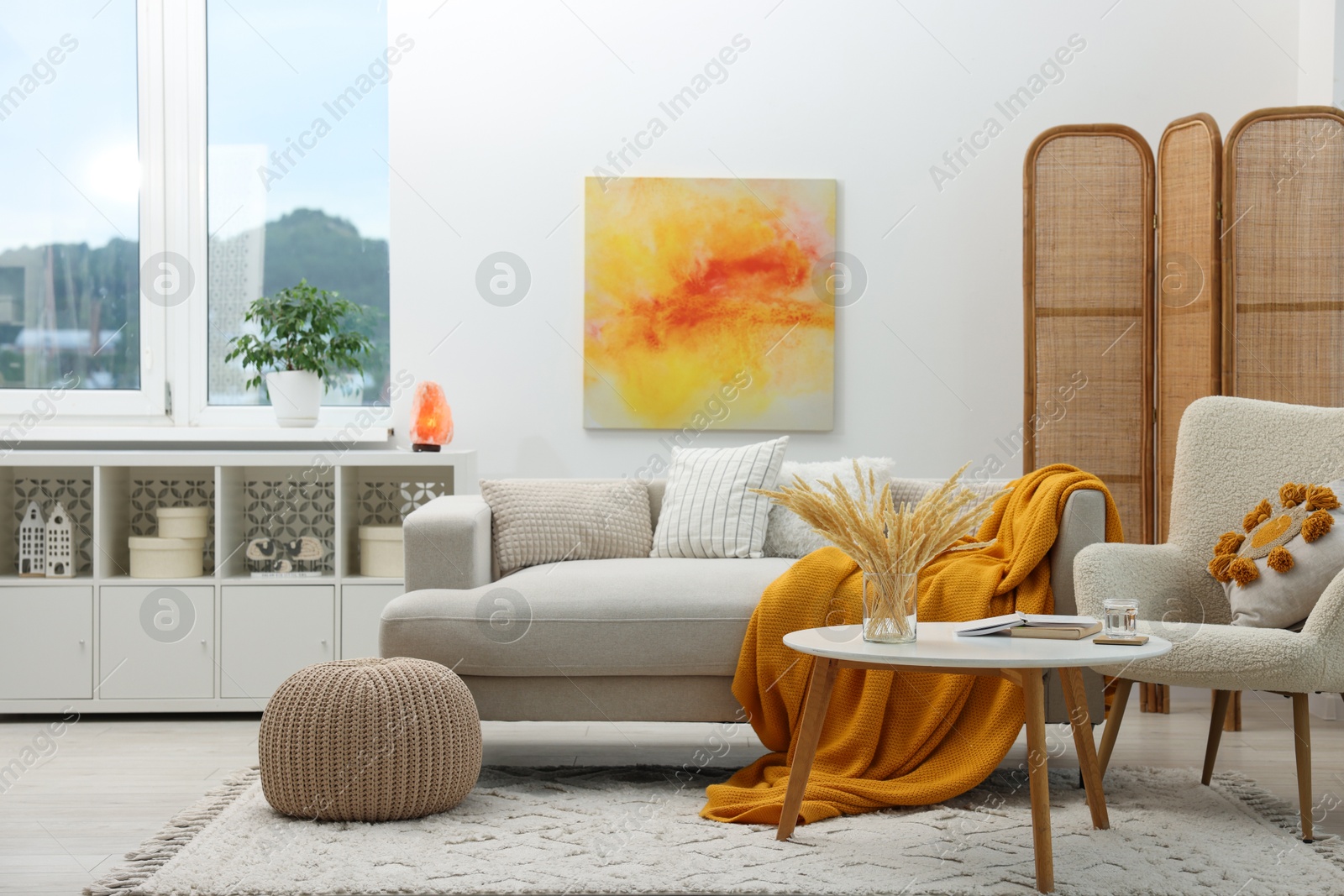 Photo of Comfortable sofa, armchair, coffee table and folding screen in living room