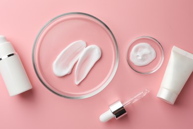 Petri dishes with cosmetic products and pipette on pink background, flat lay