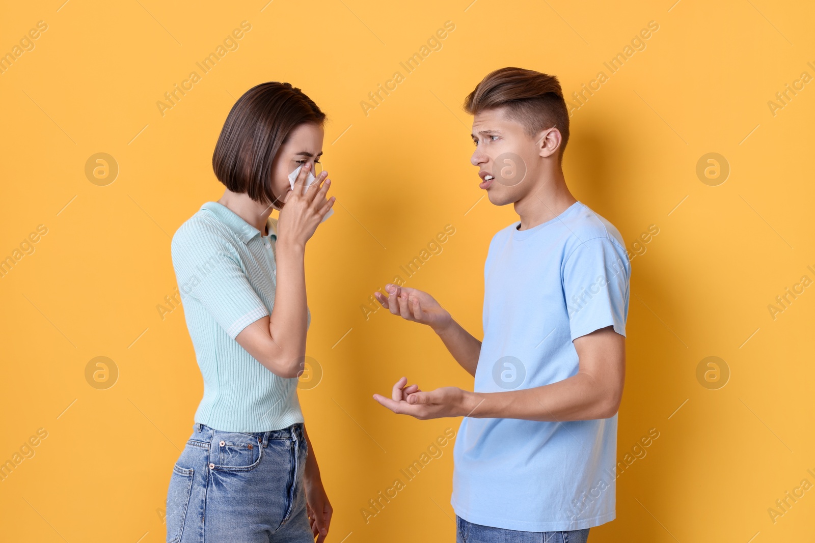 Photo of Crying woman arguing with her boyfriend on orange background