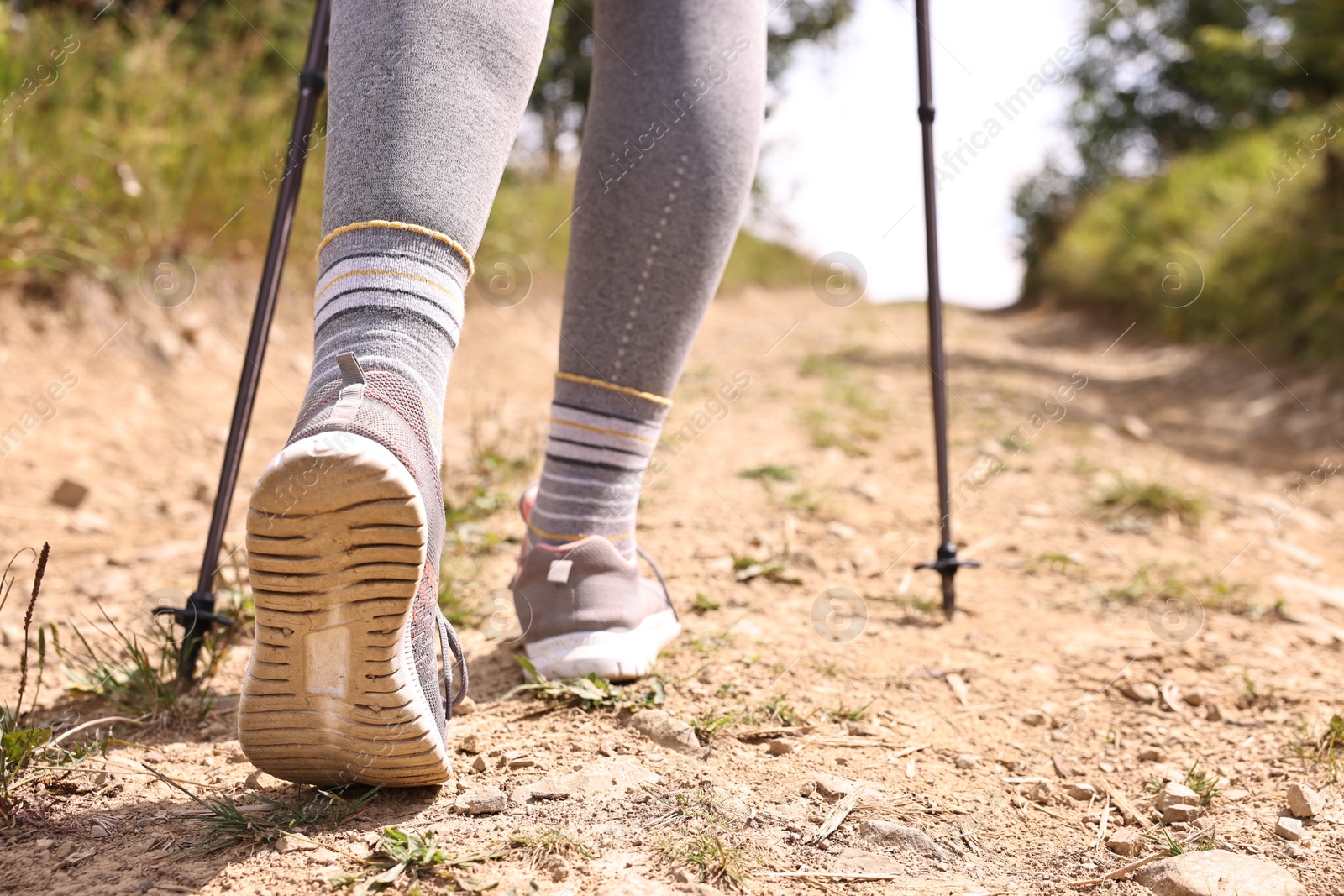 Photo of Young hiker with trekking poles outdoors, closeup