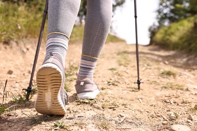 Young hiker with trekking poles outdoors, closeup