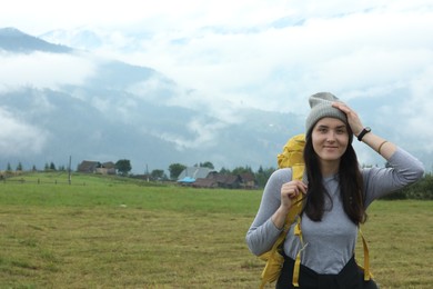 Young hiker with backpack in mountains. space for text