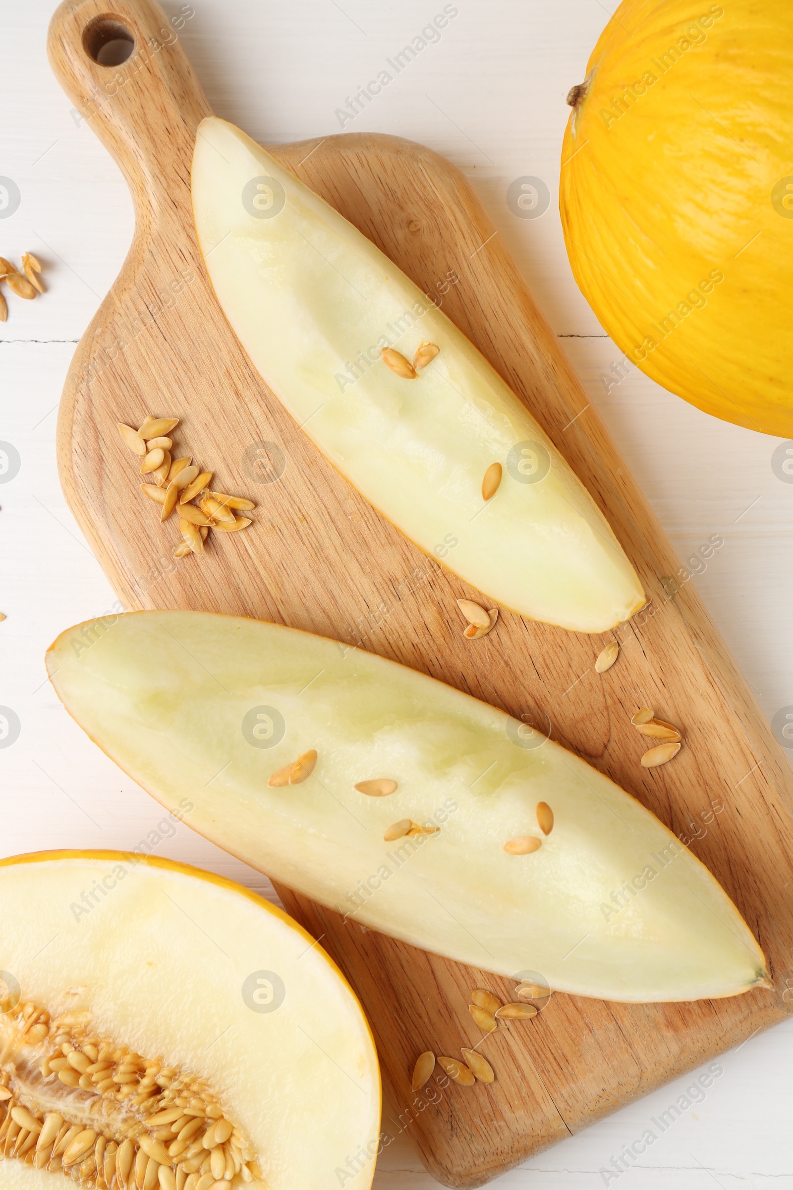 Photo of Fresh ripe melons on white wooden table, flat lay