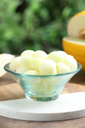 Photo of Fresh ripe melon balls in dessert bowl on table outdoors, closeup