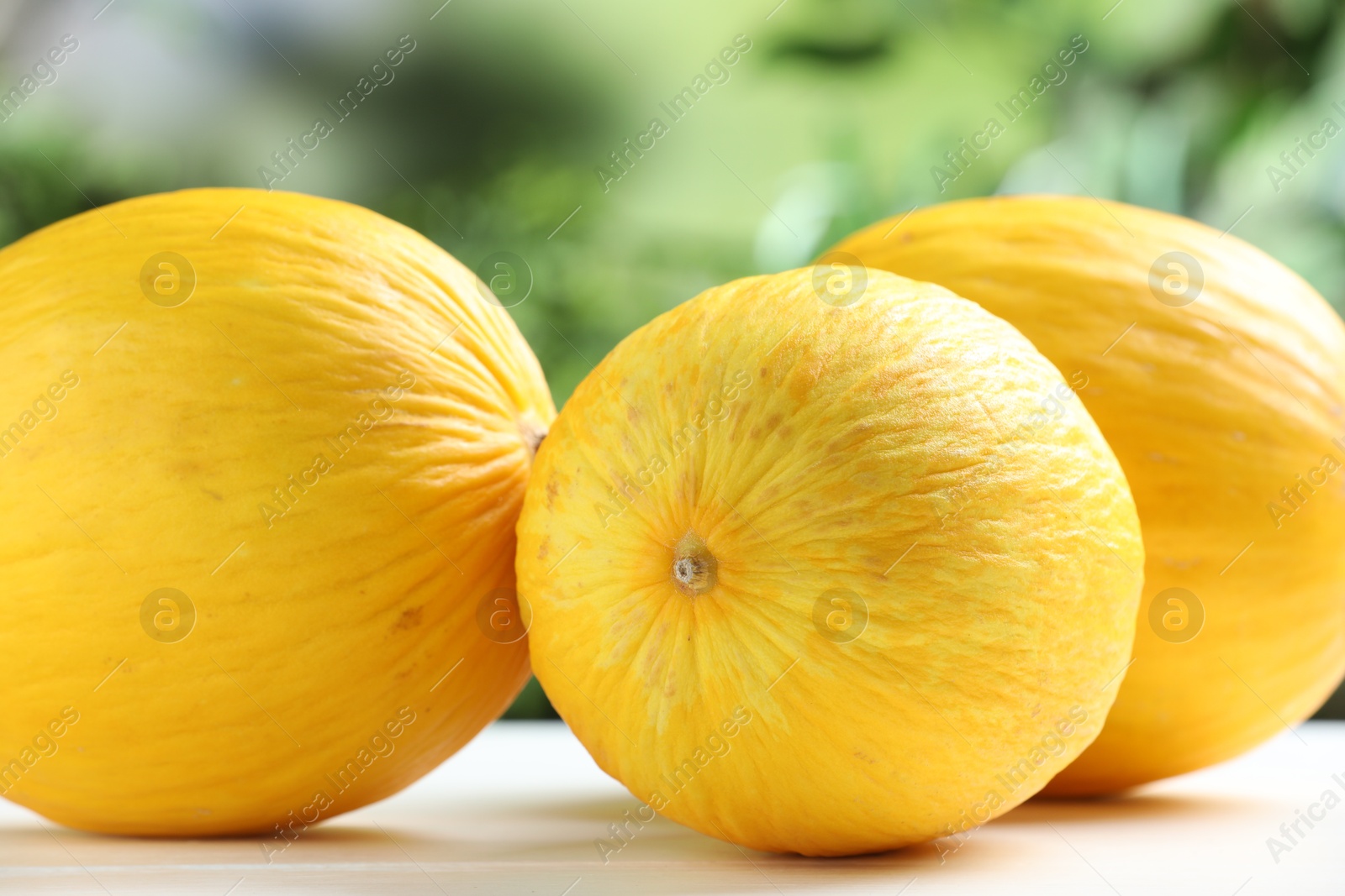 Photo of Fresh ripe melons on white table outdoors, closeup