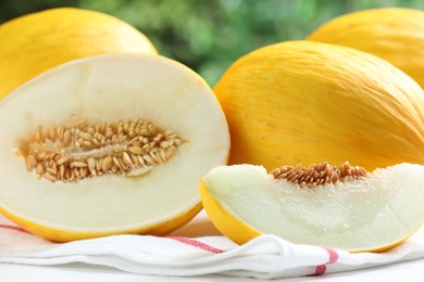 Photo of Fresh ripe melons on white table outdoors, closeup