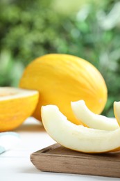 Photo of Fresh ripe melons on white table outdoors