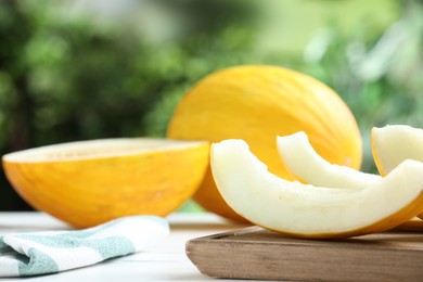 Photo of Fresh ripe melons on white table outdoors, space for text