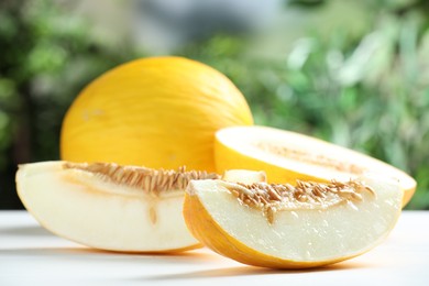 Photo of Fresh ripe melons on white table outdoors, closeup