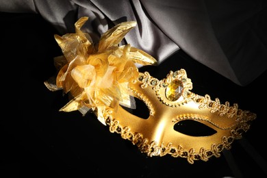 Beautiful golden carnival mask on black background, above view