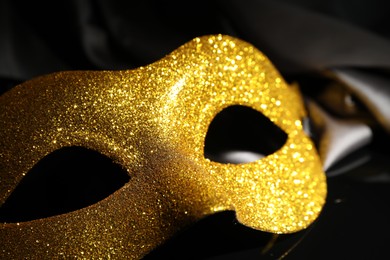 Beautiful golden carnival mask on black background, closeup